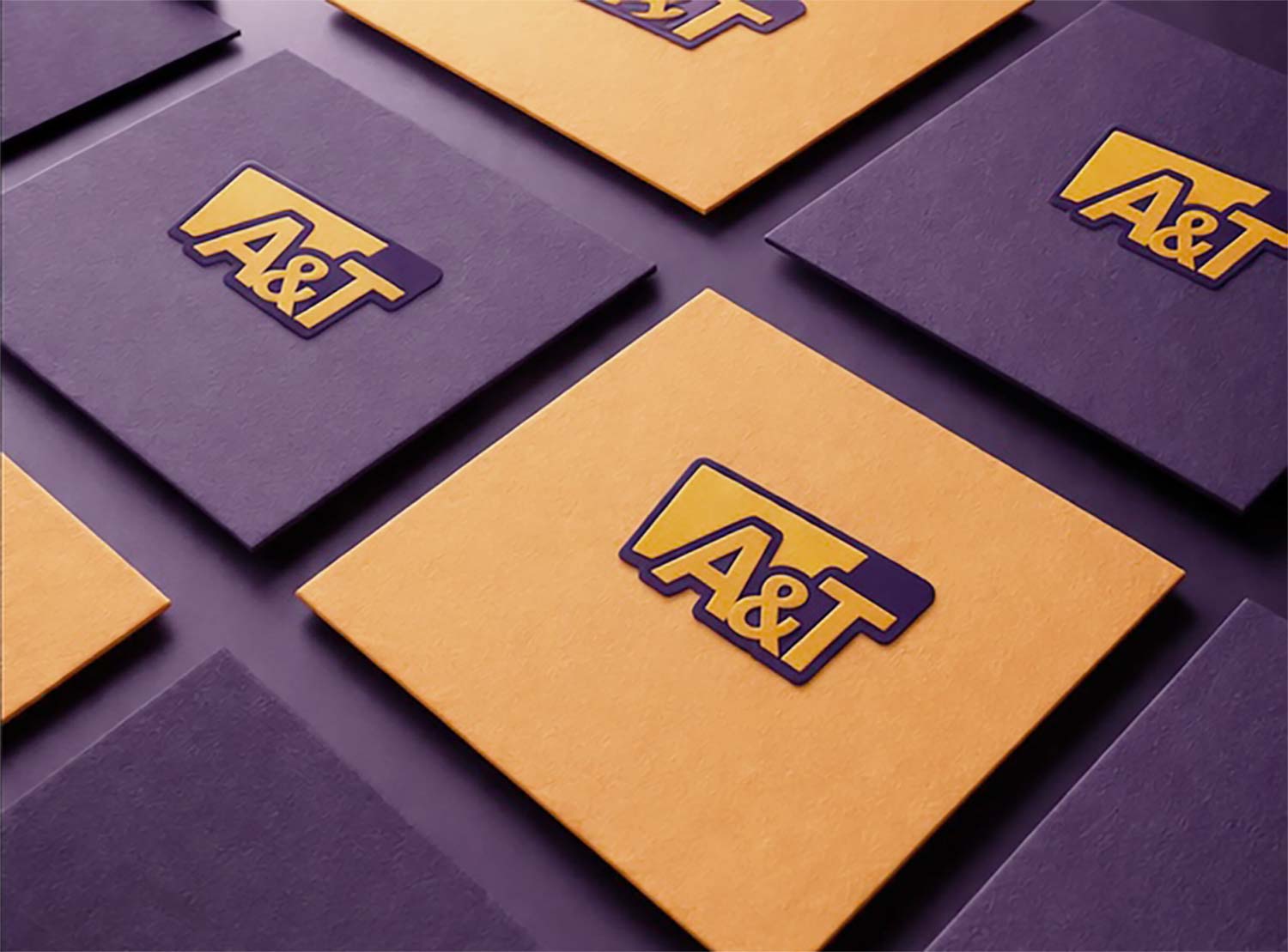 Biglietti da visita con logo A&T in viola e arancione su sfondo elegante