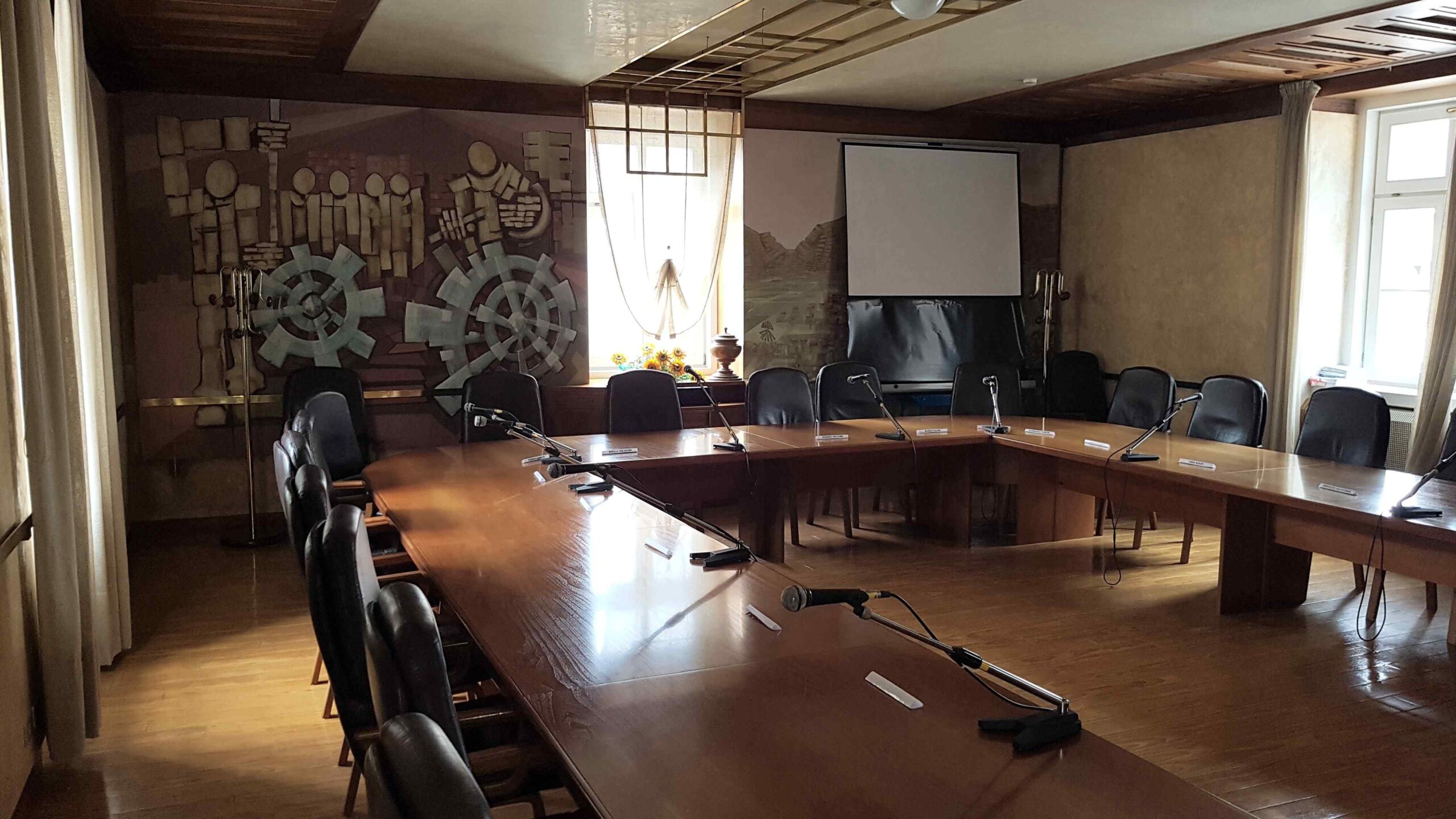 Sala consigliare di Tione con schermo di proiezione e sistema microfoni da conferenza