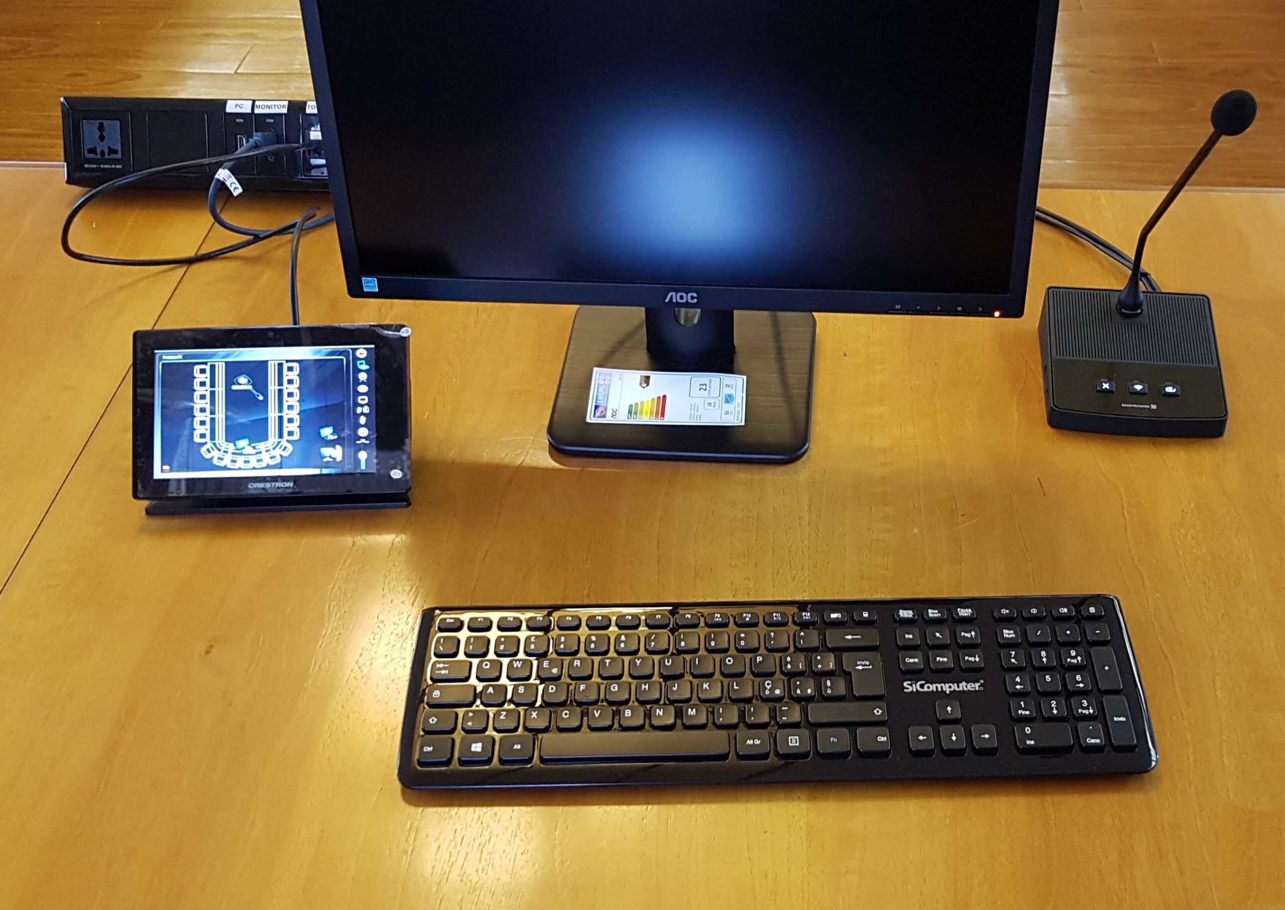 Postazione di regia con touch panel Crestron, monitor, tastiera e microfono a Tione