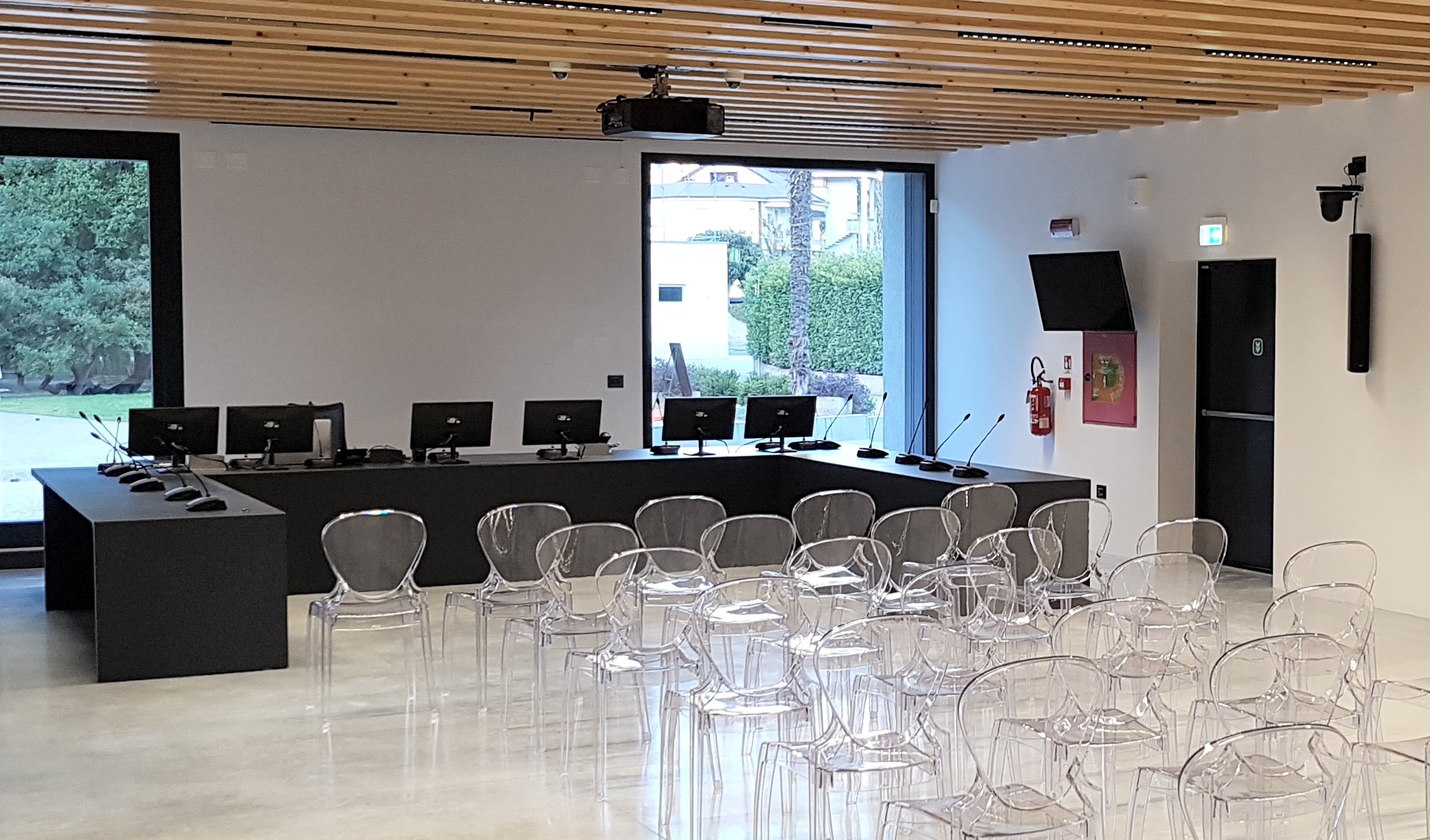 Sala consiliare di Torbole con banco relatori, microfoni, monitor TV e diffusori audio a parete
